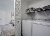 Thumbnail 27 of 38 - A laundry room with a washer and dryer.