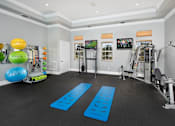 Thumbnail 19 of 28 - A spacious home gym with a variety of exercise equipment and a mirrored wall.
