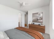 Thumbnail 17 of 41 - a bedroom with white walls and a bed with an orange blanket