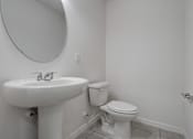 Thumbnail 26 of 36 - A white toilet sits next to a sink in a bathroom.