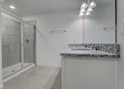 Thumbnail 23 of 36 - A bathroom with a walk-in shower and a marble countertop.