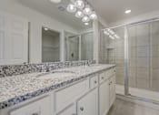 Thumbnail 21 of 36 - A bathroom with granite countertops and a walk-in shower.