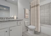 Thumbnail 22 of 36 - A white bathroom with a toilet, sink, and shower.