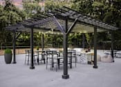 Thumbnail 13 of 16 - Greentree Apartments in Savannah, GA photo of a patio with tables and chairs and a pergola