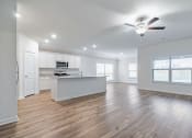 Thumbnail 6 of 46 - Four Bedroom Homes for Rent in Denton, TX - Beall Way - Open-Concept Living Room with a Ceiling Fan and a View of the Kitchen and Dining Room.
