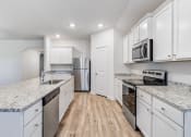 Thumbnail 3 of 46 - Three-BR Homes For Rent In Denton, TX - Beall Way - Kitchen With Stainless Steel Appliances, Granite Countertops, Kitchen Island, And White Cabinets For Lots Of Storage Space