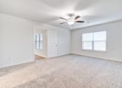 Thumbnail 9 of 46 - Homes In North Denton, TX For Rent - Beall Way - Spacious Bedroom With Plush Carpeting, Ceiling Fan, And Windows