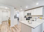 Thumbnail 5 of 46 - a kitchen with white cabinets and a marble counter top