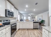Thumbnail 4 of 46 - a large kitchen with white cabinets and stainless steel appliances