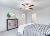 Thumbnail 10 of 46 - Four BR Apartments in North Denton, TX - Beall Way - Large Furnished Bedroom with Wall-to-wall Carpeting, Ceiling Fan, Large Closet, and Attached Bathroom.