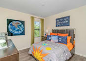 Thumbnail 26 of 35 - A bedroom with a bed, a dresser, and a painting of the Earth on the wall.