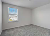 Thumbnail 32 of 36 - A room with a window and a carpeted floor.