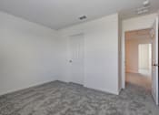 Thumbnail 34 of 36 - A room with a carpeted floor and a white door.