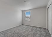 Thumbnail 28 of 36 - A room with a carpeted floor and a window with blinds.