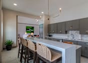 Thumbnail 13 of 18 - Modern clubhouse kitchen and entertaining space at Blue Sky Landing apartments in College Park, GA featuring island seating near Camp Creek Marketplace, East Point and South Fulton.