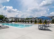Thumbnail 9 of 18 - Spacious pool deck with lounge seating at Blue Sky Landing pet-friendly apartments in College Park, GA near Camp Creek Marketplace, East Point and South Fulton.