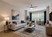 Thumbnail 5 of 18 - Thoughtfully designed living room at Blue Sky Landing featuring an open-concept layout, modern furnishings, wood-style flooring, and large windows in a pet-friendly one-, two-, and three-bedroom apartment community in College Park, GA.