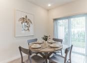 Thumbnail 12 of 30 - Boatman Hammock Townhomes in Lake Worth, FL photo of a dining room with a table and chairs and a window