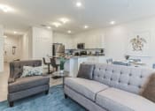 Thumbnail 8 of 30 - Boatman Hammock Townhomes in Lake Worth, FL photo of a living room with a couch and a chair and a kitchen