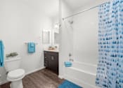 Thumbnail 5 of 26 - A white toilet sits next to a white sink in a bathroom.