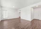 Thumbnail 9 of 26 - A room with wooden flooring and white walls.