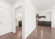 Thumbnail 7 of 26 - A kitchen with white cabinets and a wooden floor.