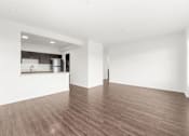Thumbnail 6 of 26 - A room with wooden flooring and white walls.