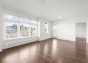 Thumbnail 8 of 26 - A room with wooden flooring and white walls.