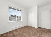 Thumbnail 11 of 26 - A room with a window and carpeted floor.