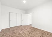 Thumbnail 14 of 26 - A room with white walls and brown carpet.