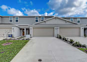 Thumbnail 1 of 36 - A residential house with a grey roof and two garages.