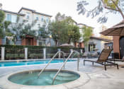 Thumbnail 11 of 14 - Pet-Friendly Apartments in Tustin, CA - Tustin Cottages - Pool with a Jacuzzi, Trees, and Brown Lounge Chairs