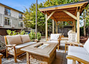 Thumbnail 31 of 42 - A wooden patio with a couch, chairs, and a table.