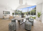 Thumbnail 21 of 35 - Apartments in Savannah, GA for Rent – The Palms at Chatham- our clubhouse with a large wooden table and stools in front of a large window