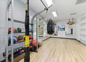 Thumbnail 18 of 35 - Apartments in Savannah, GA for Rent – The Palms at Chatham- a home gym with weights and a punching bag