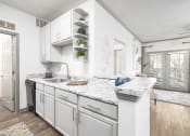Thumbnail 5 of 35 - Pet-Friendly Apartments in Savannah, GA – The Palms at Chatham – a kitchen with white cabinets and granite countertops
