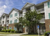 Thumbnail 30 of 35 - Pet-Friendly Apartments in Savannah, GA – Canvas at Savannah – our apartment building with white siding and green shutters