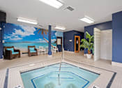 Thumbnail 4 of 47 - A large indoor swimming pool with a mural of a beach scene on the wall.