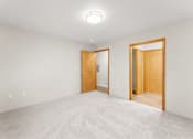 Thumbnail 13 of 47 - A room with two doors and a carpeted floor.