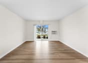 Thumbnail 10 of 47 - A large empty room with wooden floors and white walls.