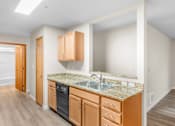 Thumbnail 6 of 47 - A kitchen with wooden cabinets and a granite countertop.