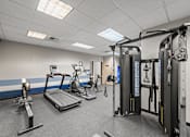 Thumbnail 35 of 47 - A gym with a treadmill, weights, and exercise equipment.