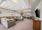 Thumbnail 43 of 47 - A spacious living room with a grey sofa set and a television.
