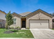 Thumbnail 10 of 41 - a tan brick house with a white garage door