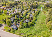 Thumbnail 33 of 34 - A residential area with houses surrounded by trees.