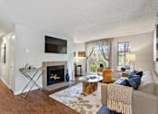 Thumbnail 6 of 34 - A living room with a fireplace and a television.