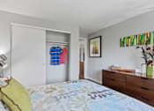 Thumbnail 12 of 34 - A bedroom with a bed, dresser, and a painting on the wall.