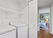 Thumbnail 13 of 34 - A small laundry room with a washer and dryer.