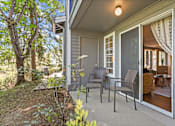 Thumbnail 15 of 34 - A patio with chairs and a table is on the front porch of a house.