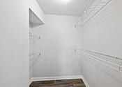Thumbnail 11 of 25 - Sandy Springs, GA Apartments – Celebration at Sandy Springs – A white walk in closet with shelves and a light on the ceiling.